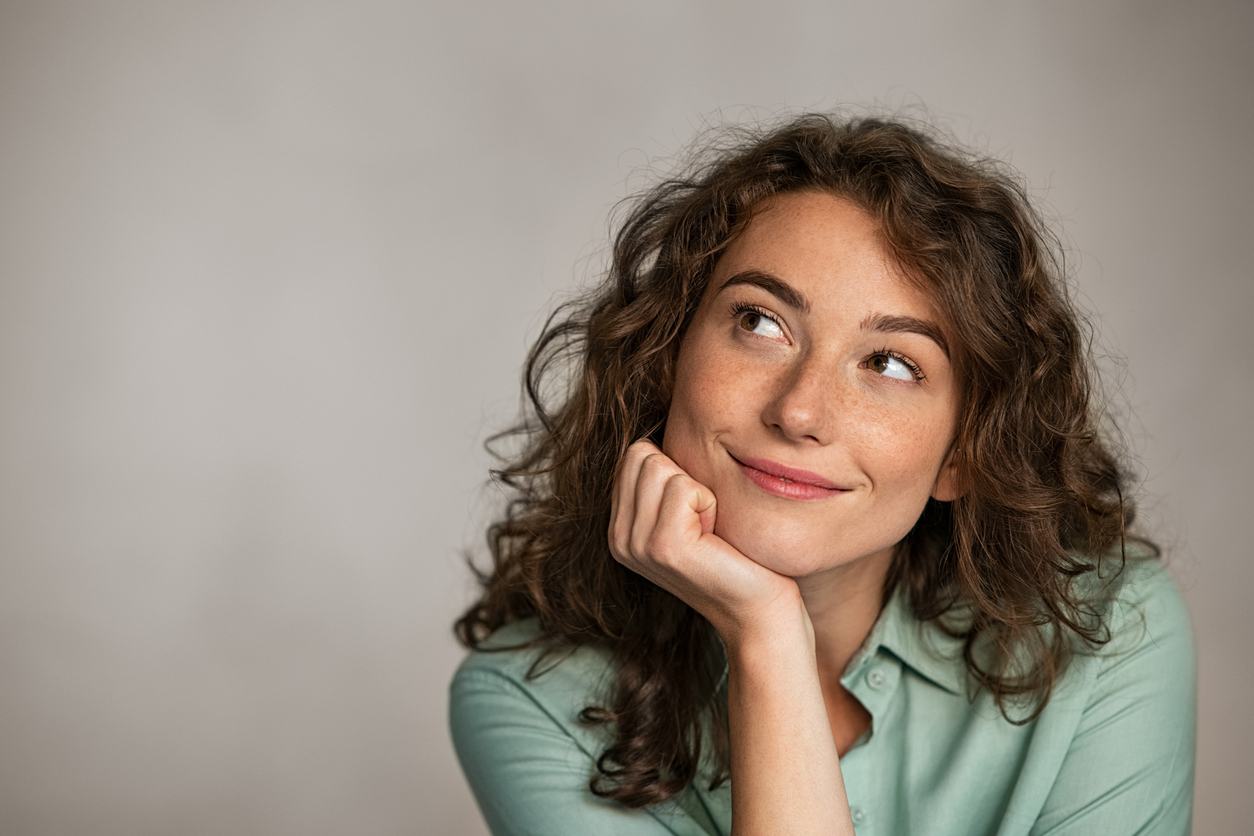 Mulher reflexiva pensando nos motivos pelos quais as empresas não devem menosprezar o marketing digital